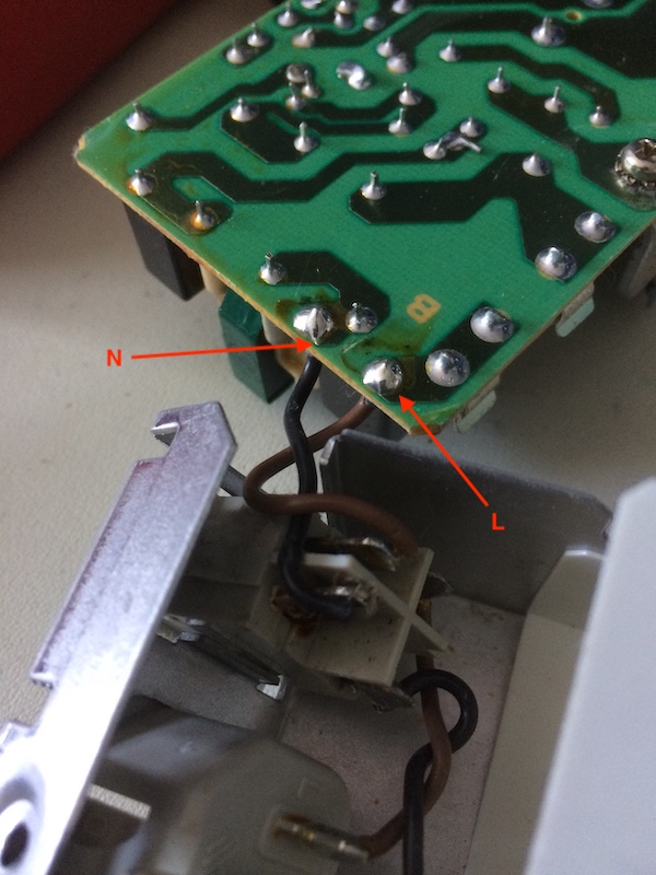 Desoldering the power supply board from the switch. The brown wire is marked "L" on the board, and the black wire is marked "N"
