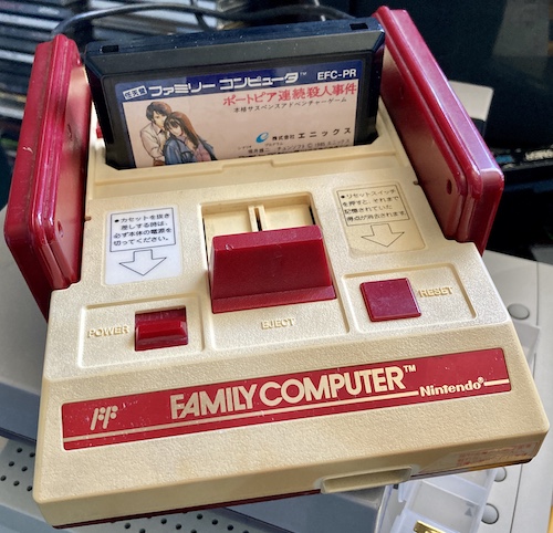 The Famicom, reassembled and with a copy of Portopia in the cartridge slot. It's sitting on top of a Bandai Pippin (spoiler alert.)