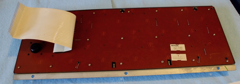 Backside of the keyboard PCB. There are stickers reading MITSUMI 841102 and 46442511
