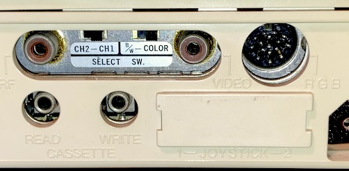 The ports on the leftmost side of the case when the rear is facing you: composite video, RF video, a blocked-off joystick port, read/write cassette, channel and colour selects, and an 8-pin DIN marked "RGB."