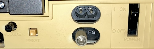 The power port, volume knob, reset button, frame-ground connector, and power switch.