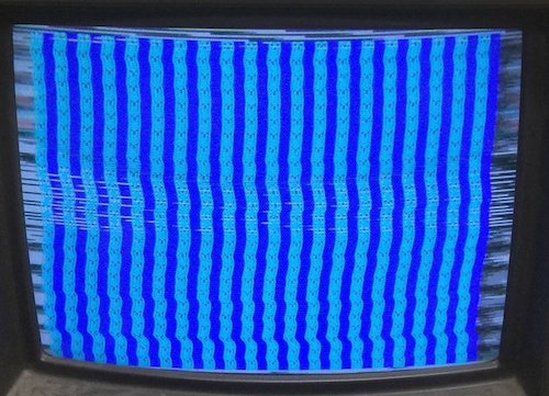 The video problem. Every tile of the video has a ¥ symbol in it. Every first column has a dark blue background and every second column has a light blue background. The video is wobbling and tearing dramatically from bad sync, including some glitchy white lines in the middle where a scanline appears to be getting filled with noise.