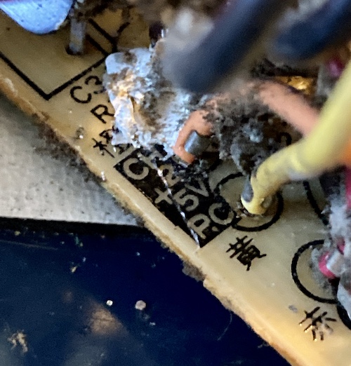 A disgusting mess of dirt and silastic gives way to an orange wire connected to CH 2 and a yellow wire connected to 5V P.C.