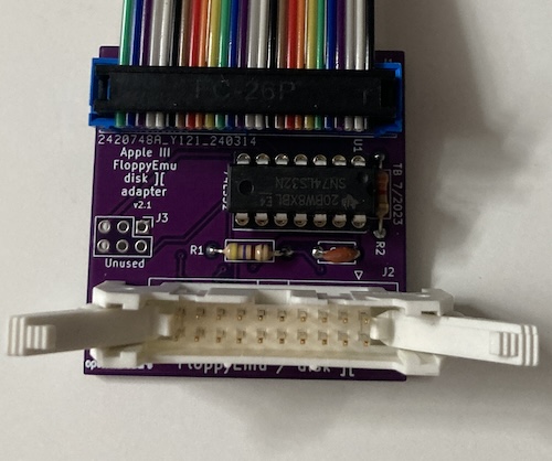 The Floppy Emu/Disk II adapter board, assembled. It has a purple PCB and a single 74LS32, along with a huge 20 pin connector.