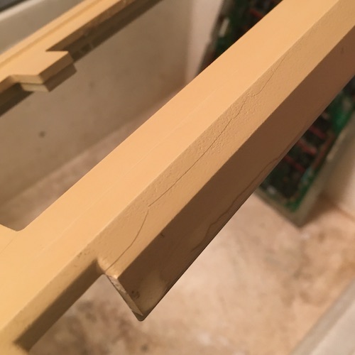 The crack on the keyboard frame, around the recess for the reset button.