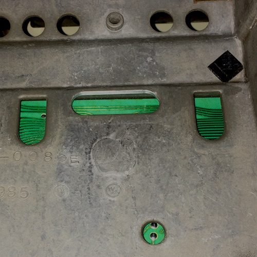 An Apple logo is shown on the aluminum underneath the keyboard tray.