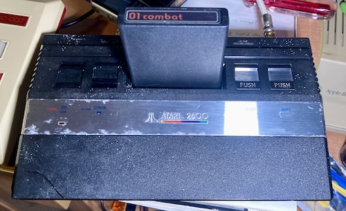 The Atari 2600 Jr is photographed under harsh lighting that shows all of its many cosmetic flaws.