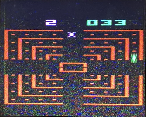 A snowy orange maze shows some buglike cars racing around a concentric ring without concern for traffic law or personal safety.