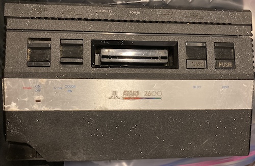 The Atari 2600 Jr in question. It has a missing corner, is filthy, and is spattered with paint.