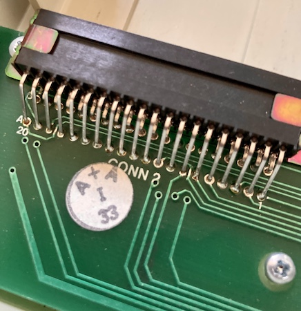 The cartridge slot is soldered into the board. It has a pair of rainbowy metal braces holding it in.