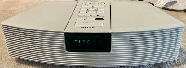 The WaveRadio, freshly repaired, sitting on my carpeted floor, playing FM radio, getting fairly hot. The time displayed is 12:51 AM