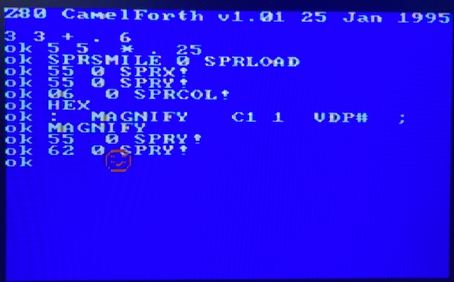 A red smiley face is on the screen, with the code required to spawn it in the background.