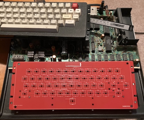 The dry fit into the CoCo bottom case shows that the unpopulated red PCB installs cleanly.