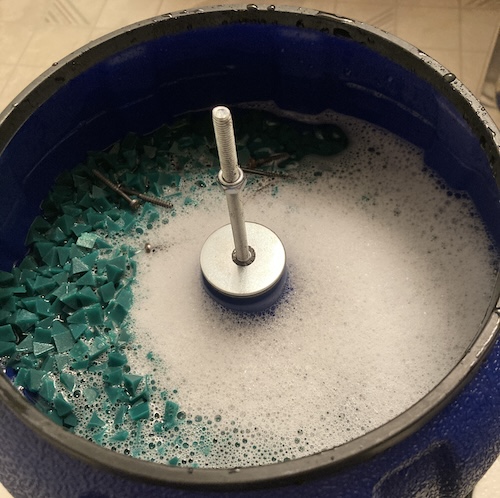 The screws are now in a soup of a bunch of green plastic pyramids with some foaming dish soap on top.