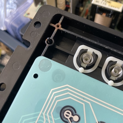 The plastic case has a pin and a screw hole, but the new membrane only has one hole.
