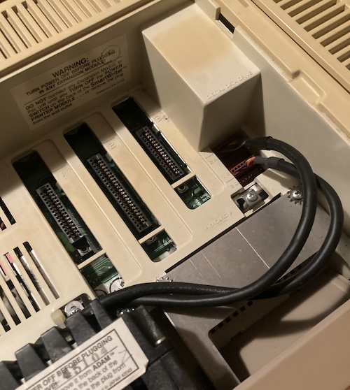 The expansion bay of the ADAM. Three card slots are shown, all of them a different pin count, and two cables snake from the back of the tape drive to the motherboard.