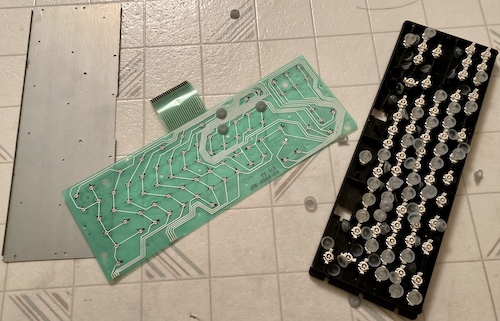 The backing plate (left), the membrane (centre) and the keyswitch plate (right.) It's all on my laundry room floor. I have lost control of my life.