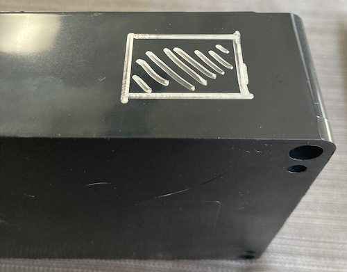 A crude rectangular hole is illustrated in the surface of the case.