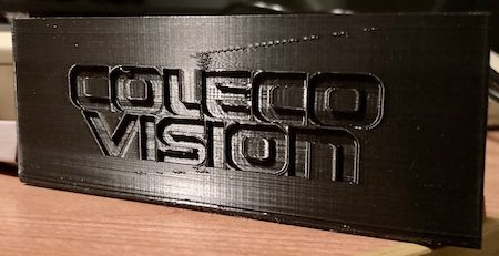 The 3D-printed battery flap, marked "COLECO VISION." It looks like there's a bit of a diagonal line where presumably the extruder tried to return to the origin while still dragging some plastic goo.