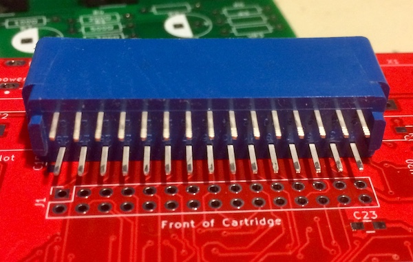 The cartridge slot is placed on top of the v0.1 test board. It is obvious that the two rows of holes in the circuit board are too close together to fit the cartridge slot, which is at least three rows deep.