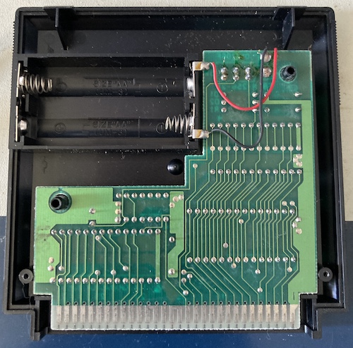 The backside of the Family BASIC cartridge is removed. You can see that there is still a little battery dust inside