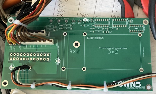 A green power supply board now has a bunch of crooked wires jutting out of it, including both main harnesses and the six signal wires.