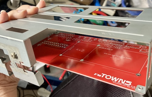 A dry fit of the red PicoPSU board into the case shows that it fits well.