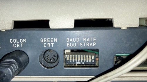 The hole on the back marked BAUD RATE/BOOTSTRAP