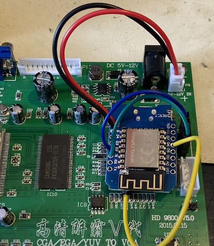 The ugly mounting of the ESP8266 dev board on top of the old MCU. It's basically just stuck on there with two-sided "Gorilla" tape, and that tape must have been bad or something, because it's not even sticking to it. You can see the yellow (debug), green (SDA) and blue (SCL) pins connected to d6, d2, and d1 on the ESP8266 board, respectively.