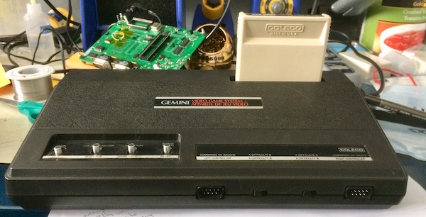 The Gemini, set up with a tan 'Venture' cartridge facing towards the back. You can only read 'Coleco' off the cartridge.