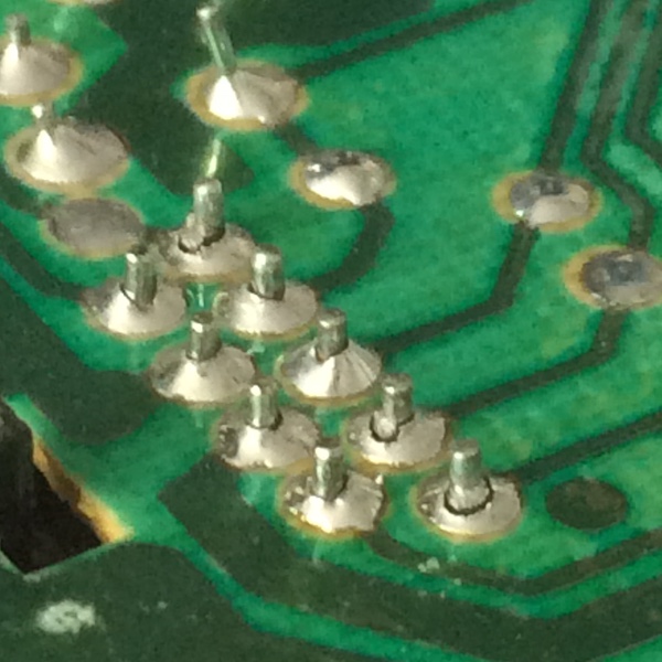 The cracked solder joints of the player-1 controller port.