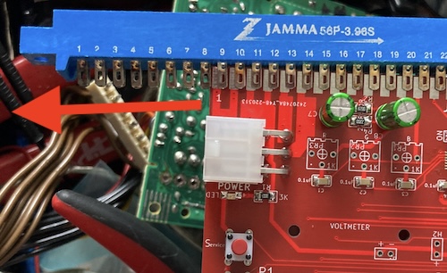 My JAMMA connector insertion technique, slowly sawing the board into the connector at an angle like a zipper. A red arrow shows the direction of movement. At this moment, the board is incomplete (missing 1k colour pots)