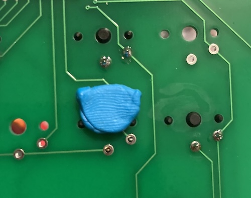 The blue sticky tack is holding the plastic pins of the switch in place, which holds the body flush against the PCB for soldering. Please don't steal my fingerprints, I need them to get into my phone.