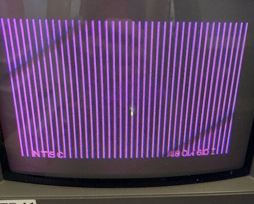 There are a bunch of white vertical lines on the PVM screen. Underneath, it says NTSC 480/60I, indicating it has acquired a sync.