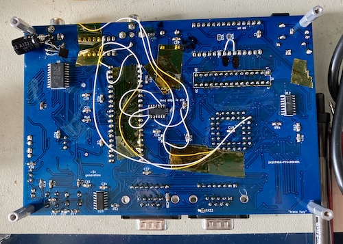 The Leako v0.5 board, populated, from the bottom. Lots of bodge wires and even more Kapton tape is running all over the board.