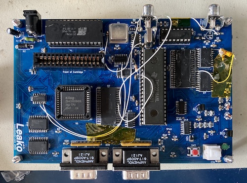 The Leako v0.5 board, populated, from the top. Lots of bodge wires and Kapton tape is running all over the board.