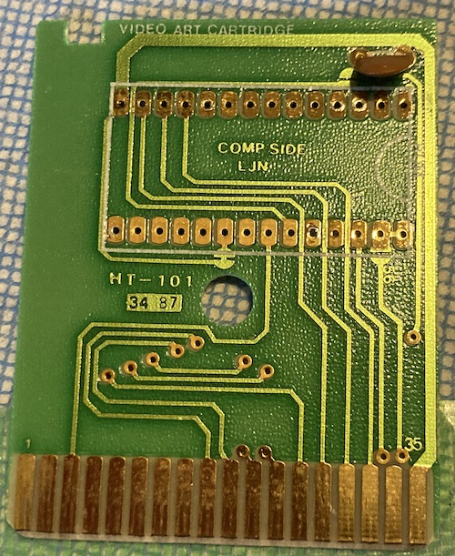 The cartridge has been denuded of its ROM, and now you can see the traces underneath where the chip usually would be.