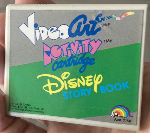 The cartridge is a grey plastic case with the "Disney Story Book" label beneath the logo for the Video Art Activity Cartridge. It is Asst. 7150