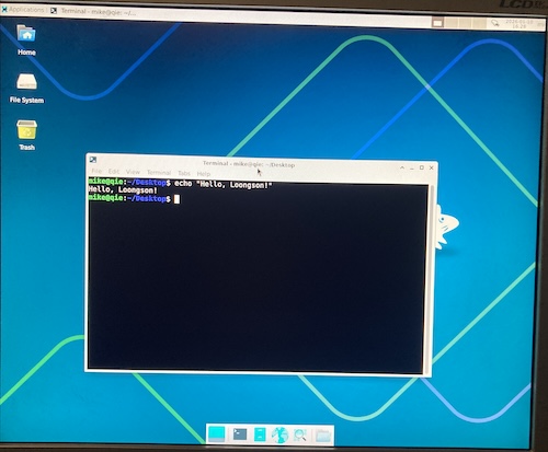 The Loongson is running Linux inside the XFCE desktop environment. A terminal is open saying "Hello, Loongson!"