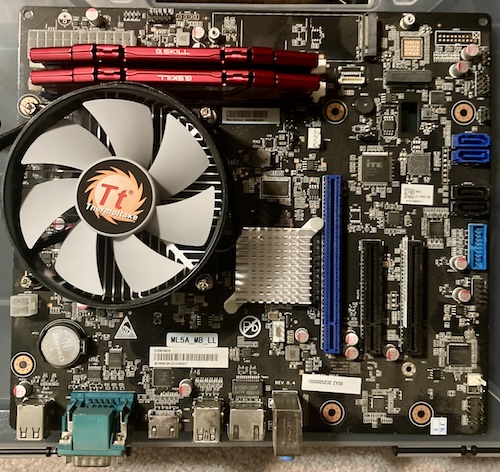 The Thermaltake cooler, and two sticks of red G.Skill RAM, are installed into the board now.