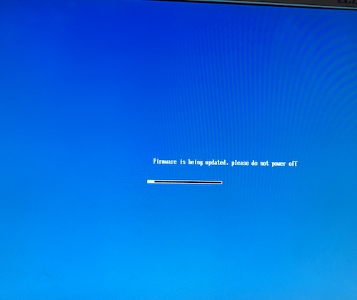 The screen is blue, and a poorly aligned string says "firmware is being updated, please do not power off." It probably expects to be a much shorter string, probably one written in Chinese.