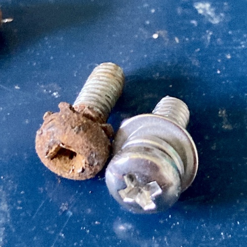The extremely rusty mounting screw (left) has been cammed out. The right screw is new.
