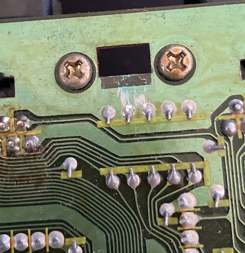 The bottom of the motherboard. There is a bunch of flux goo around the controller port on the left side, and lots of scrapes on the ground plane around the rectangular hole that the plastic motherboard clip clips into.