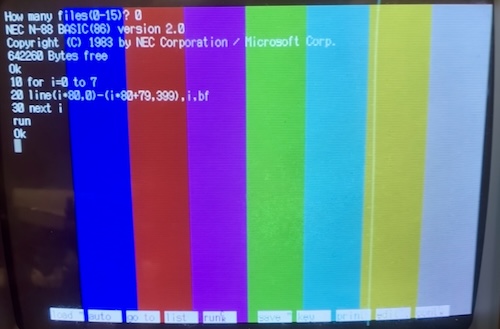 Eight fairly dim colours are shown across the screen with the aforementioned BASIC program superimposed on them.