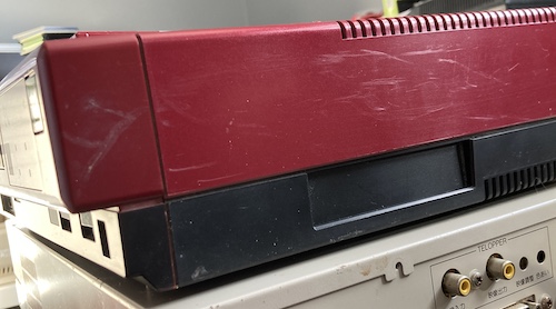 The front fascia has a pretty deep scratch in it, and the scratches continue along the side. A featureless indent is shown in the side, the cartridge slot door.