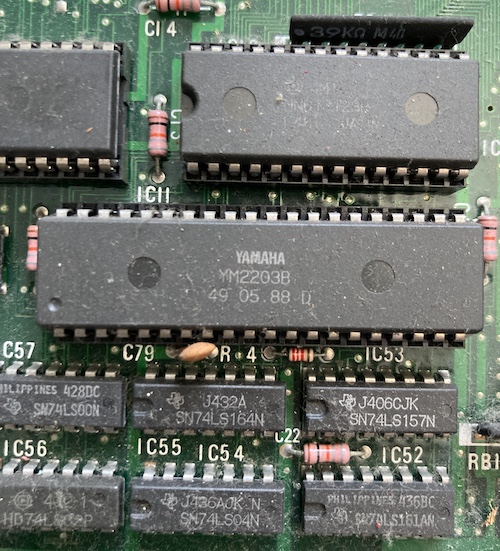 A YM2203 chip with the date code 45 05.88 at position IC11. It's covered in dust.