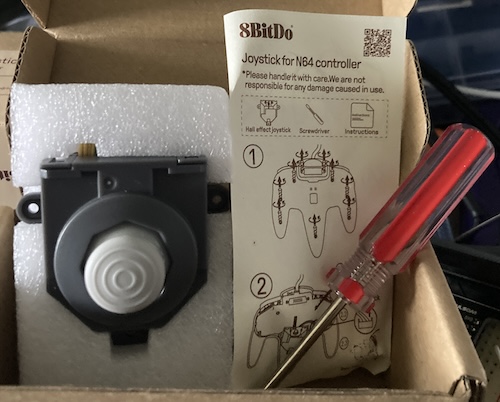The box contains a joystick module, a manual, and a screwdriver.