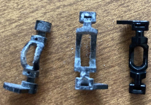 The toothed cams from the green controller, next to a new toothed cam. They are very covered in white gunk and a little loose.
