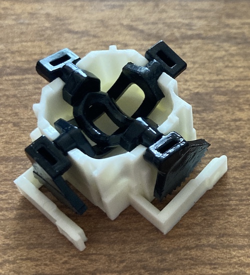 The toothed cams are installed at right angles to one another inside the new bowl. You can see that the toothed portion aligns with a holding hook, which will retain the gears.