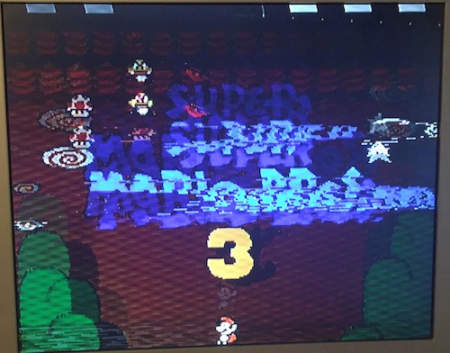Mario 3 is mostly legible, but some tiles are corrupted.